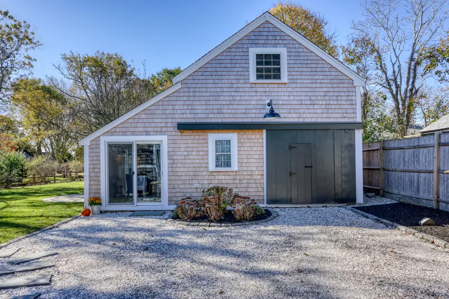 The early-1800s barn Lewis Bay Builders restored, with its shingles, slider and carriage door