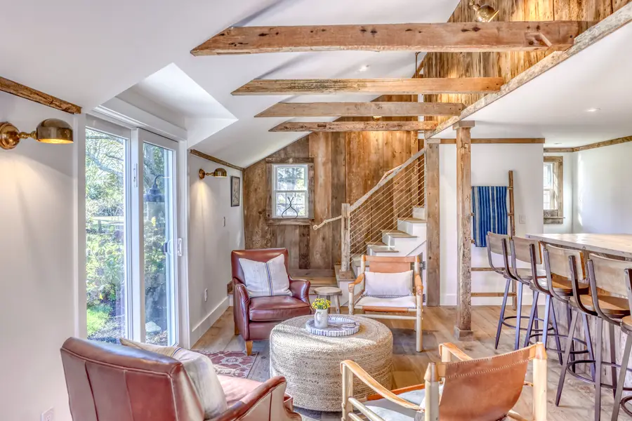 Lounge under the reclaimed beams, with the bar and staircase behind