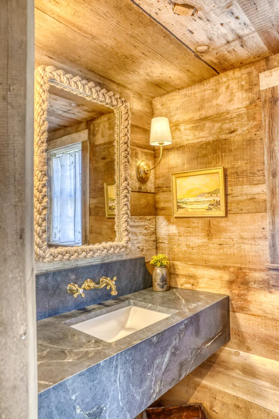 Powder room with a soapstone sink and a rope-framed mirror