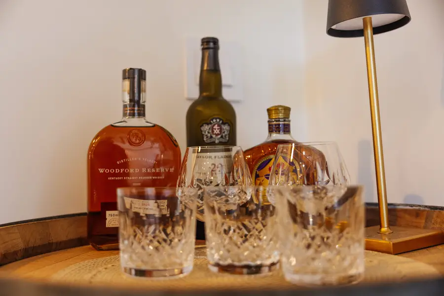 Whiskey decanters and glasses on a barrel top