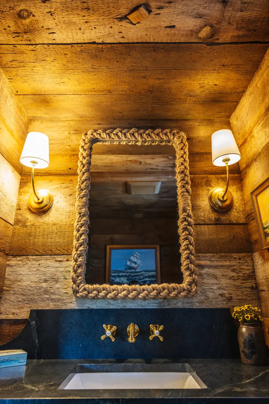 Rope-framed mirror between two sconces