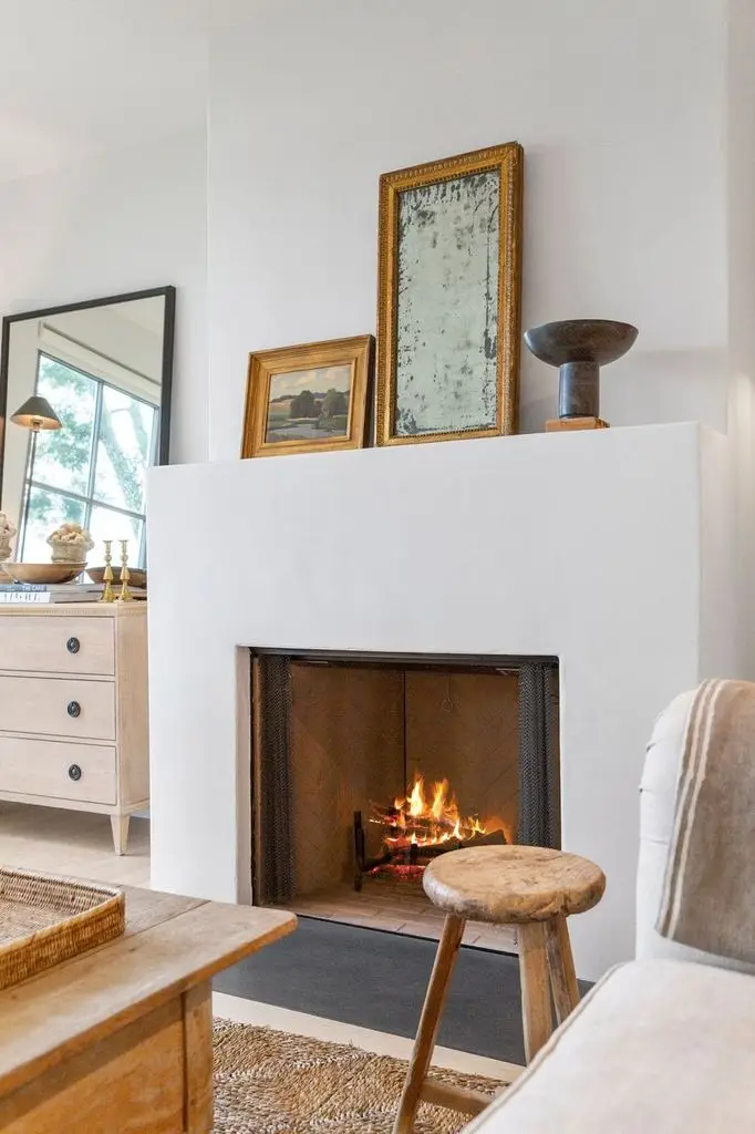 Plaster fireplace with framed art on the mantel