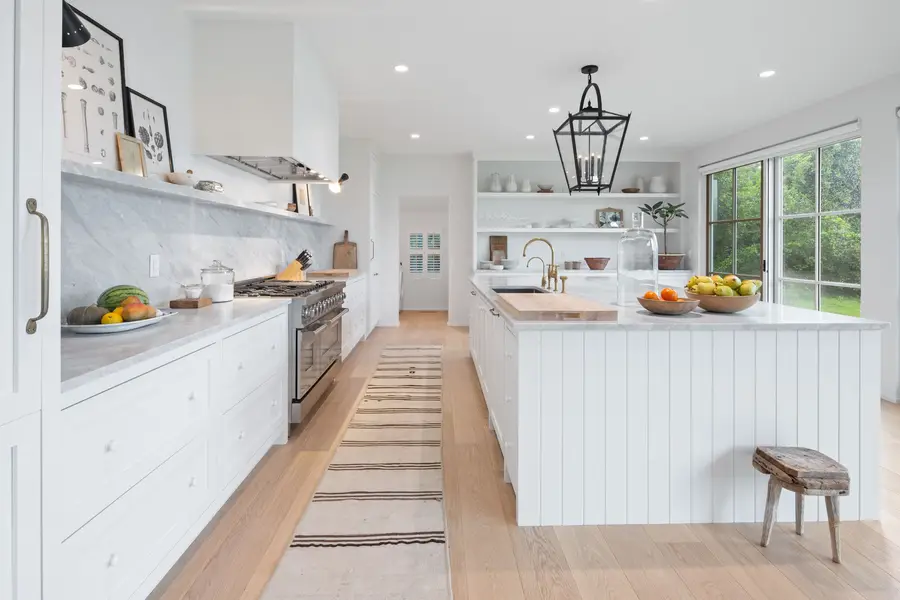 White kitchen with a long island and a lantern pendant