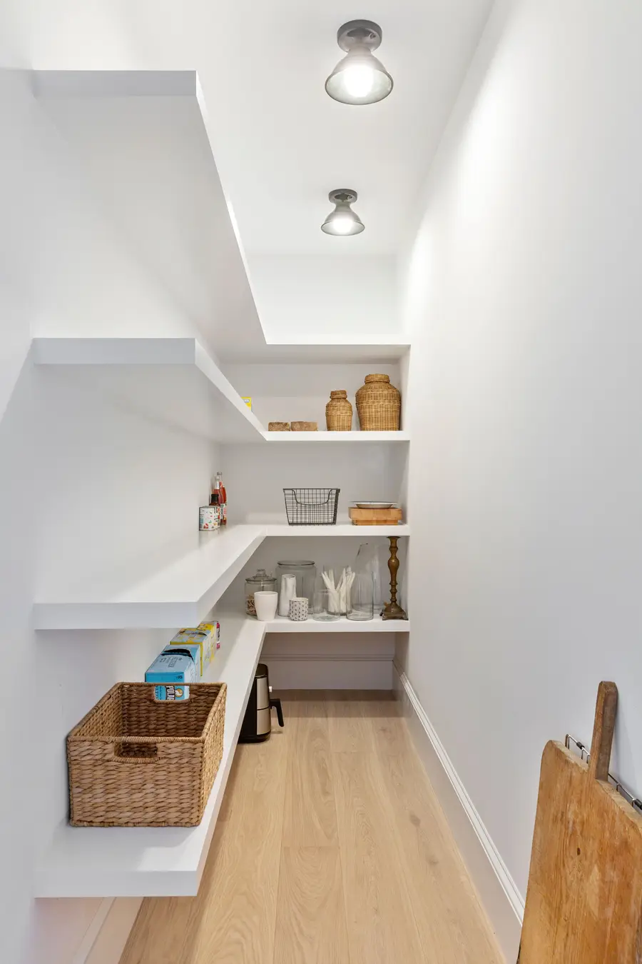 Walk-in pantry with white open shelving