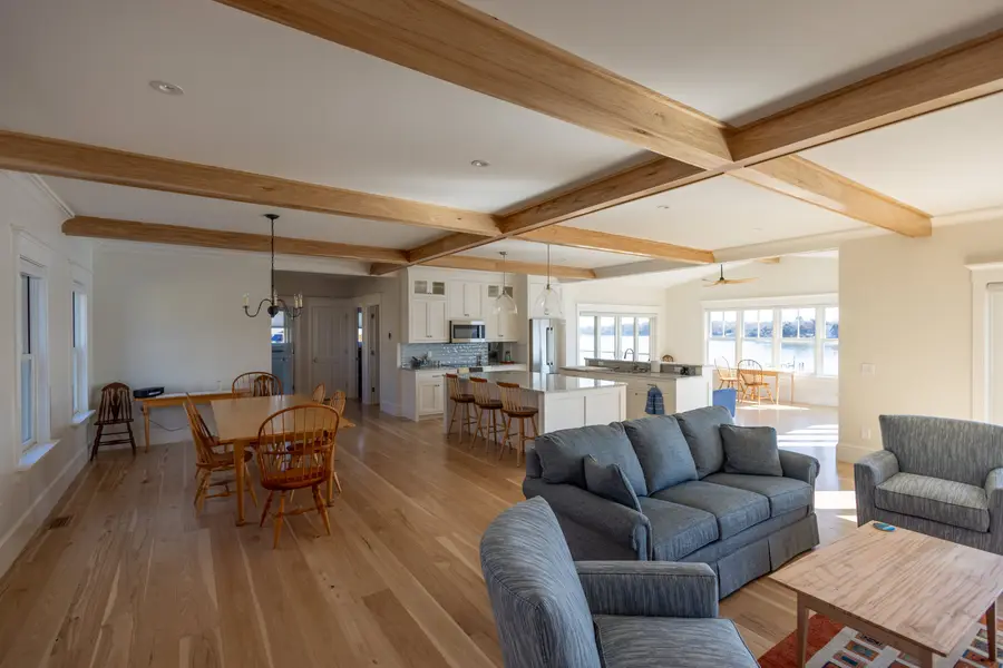 Open living room with exposed wood beams and water views