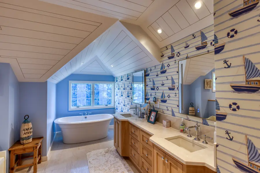New bathroom with a freestanding tub under a vaulted shiplap ceiling