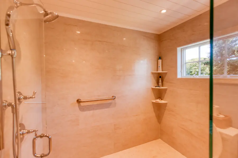 Walk-in tiled shower with a rain head and a window