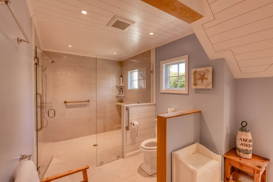 Glass shower beside the tub and the window