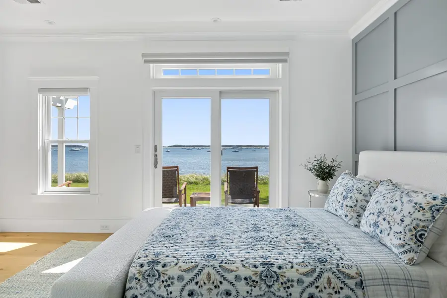 Bedroom with paneled wall and French doors to the harbor