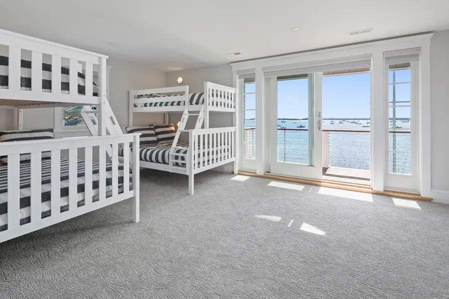 Bunk room with white built-in bunks and harbor-view windows