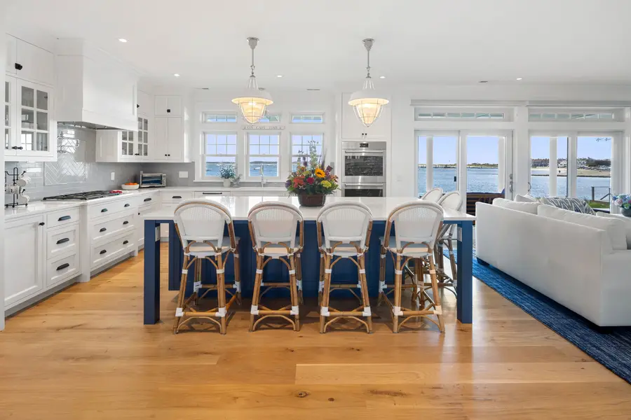 Open kitchen with a long island, pendant lights and windows on the harbor