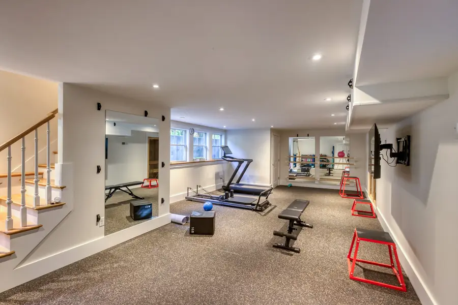 Home gym with mirrors and rubber flooring