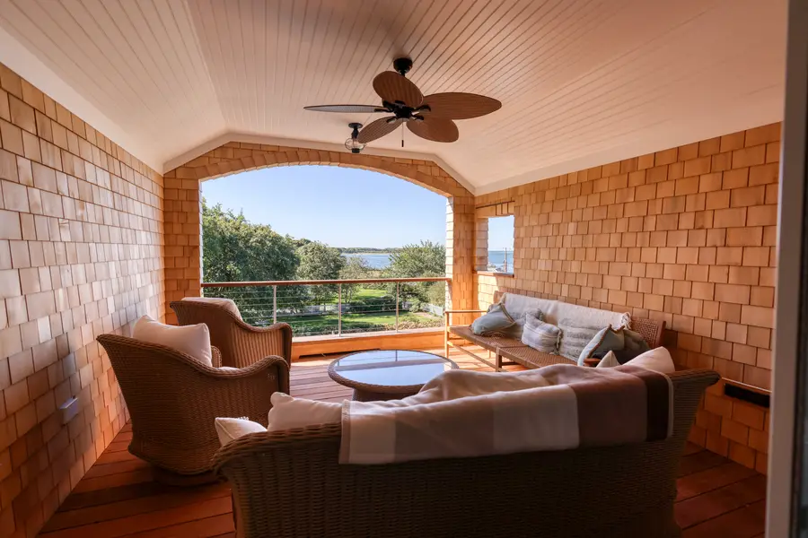 Covered porch with a ceiling fan and wicker seating