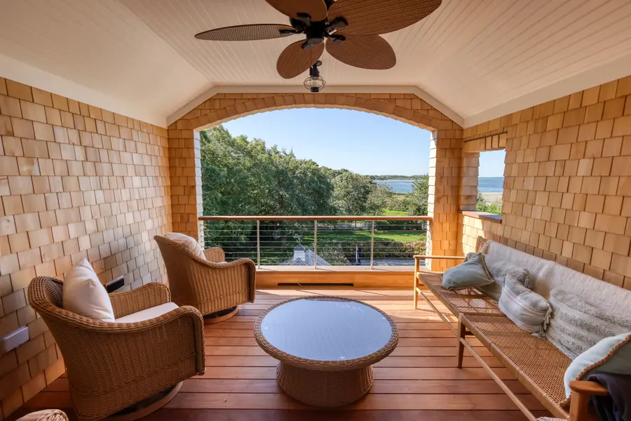 Covered porch seating with a view of the bay