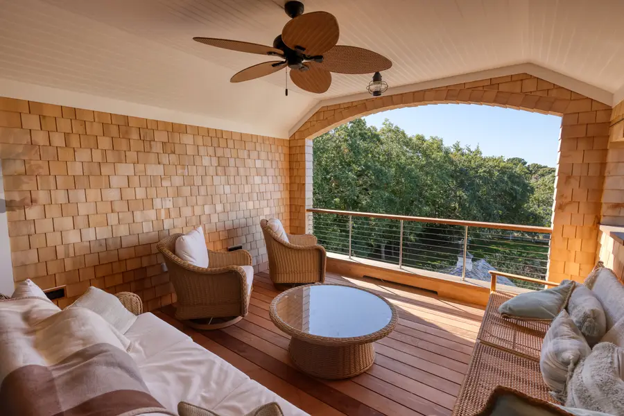 Covered porch with wicker seating and a cable rail