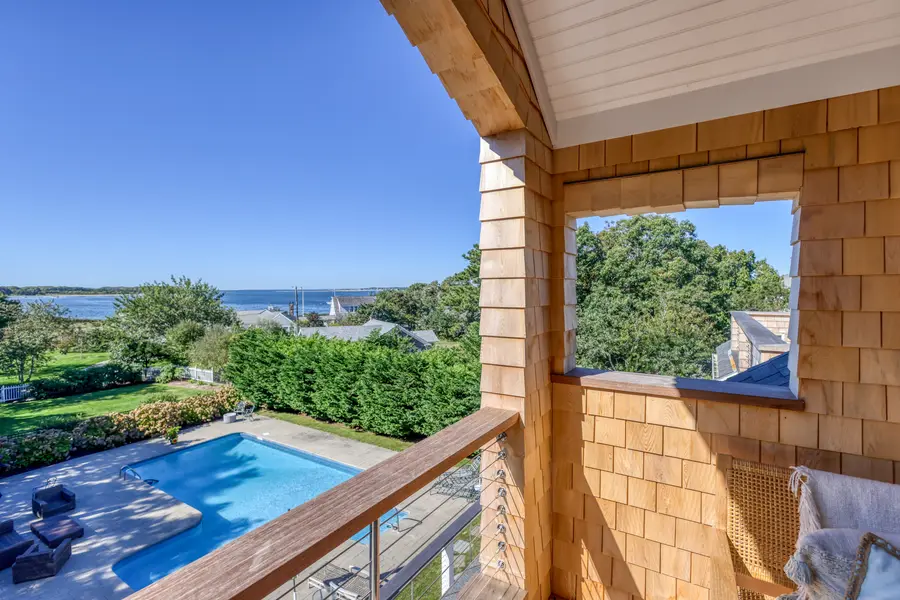 Porch opening above the pool with the water beyond
