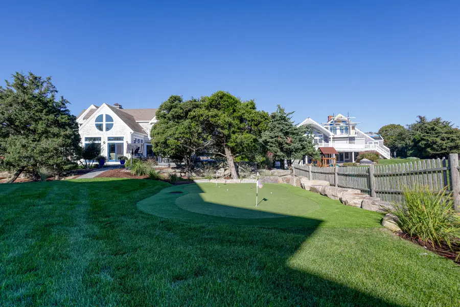 Lawn and putting green along the cedar fence