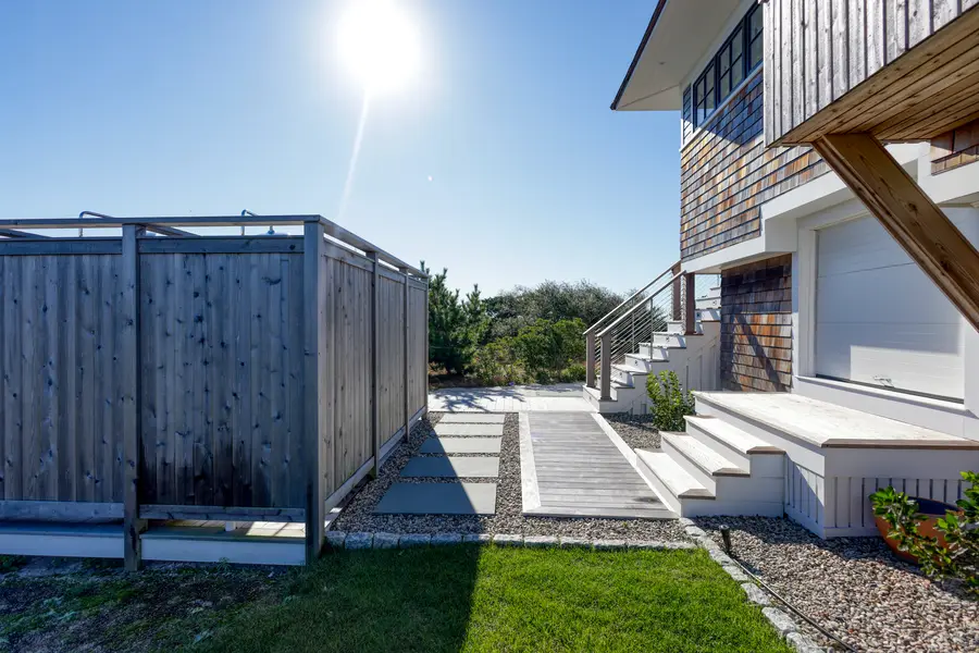 Cedar outdoor shower enclosure beside the entry walk
