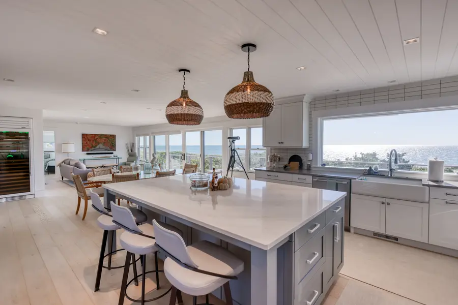 Kitchen island under copper pendants with an ocean view