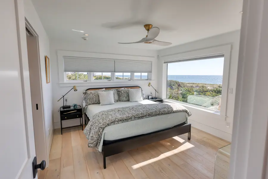 Bedroom with ceiling fan and water views