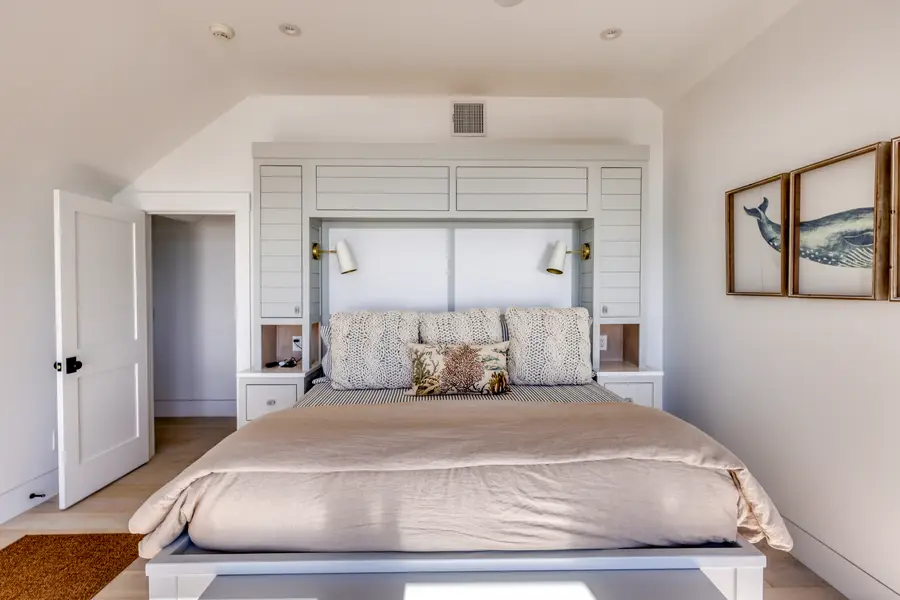 Primary bedroom with a built-in headboard wall